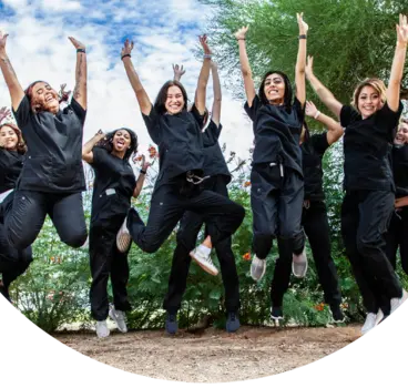 Students jumping in a pose together in their scrubs